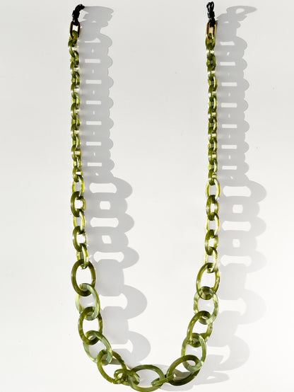 Green glasses chain necklace on a white background