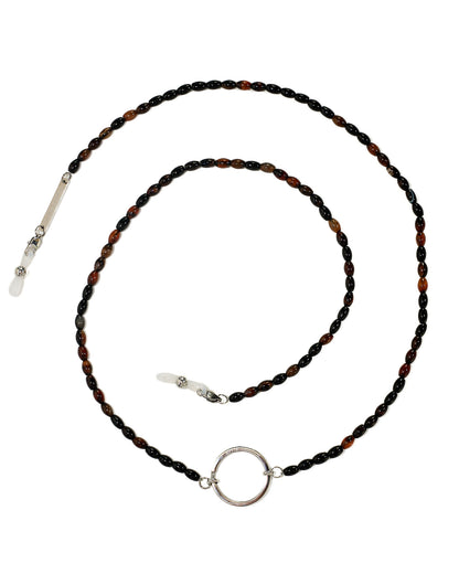 A beaded necklace with alternating dark brown and black beads, featuring a polished silver-tone circular ring at the center, a silver bar clasp, and a white stone accent on a white background.